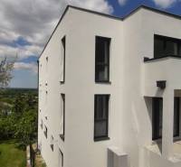 Weiße Fassade der Villa in Hainburg an der Donau mit modernen schwarzen Fenstern.
