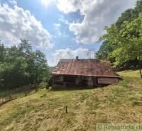 Eine Hütte in Zákopčí, umgeben von Natur und Wäldern unter blauem Himmel.