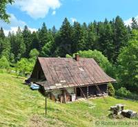 Hütte in Zákopčí, umgeben von Wäldern, Gras und Wiesen.