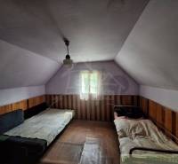 Das Innere der Hütte mit zwei Betten und Holzverkleidung, gedämpftes Licht.