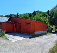 Eine Hütte in Tužina mit einem Satteldach, umgeben von Grün.