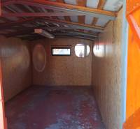Interieur einer Hütte mit Holzkonstruktion und Fenstern.