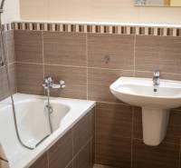 Badezimmer mit Waschbecken und Badewanne in einer 3-Zimmer-Wohnung, dezente Wandfliesen.