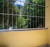 Ein kleiner Balkon mit Blick ins Grüne und Holzelemente in einer 3-Zimmer-Wohnung.