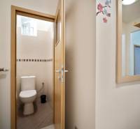 Toilette in einer 3-Zimmer-Wohnung mit Fenster und weißen Fliesen.