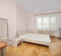 Schlafzimmer in einer 3-Zimmer-Wohnung mit Bett, Spiegel und Holzboden.