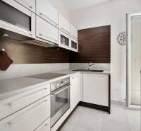 Küche in einer 3-Zimmer-Wohnung mit weißen Schränken und eingebauten Geräten.