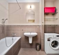 Badezimmer in einer 3-Zimmer-Wohnung mit Badewanne, Waschmaschine und Waschbecken.