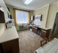 Küche in einem Einfamilienhaus mit Esstisch, Schränken und großem Fenster.