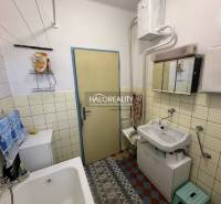 Badezimmer in einem Einfamilienhaus mit Waschbecken, Badewanne und Stauraum.