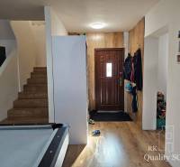 Eingangshalle in einem Einfamilienhaus mit Holztreppe und Stauraum.