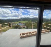 Blick von der Hütte in Korňa auf die malerische Landschaft mit Wiesen und Wäldern.
