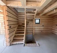 Holzinterieur der Hütte mit Betonboden und Treppe.