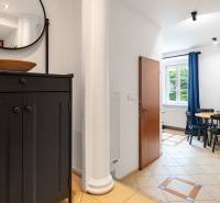 Flur mit schwarzer Kommode und Essecke in einer Zweizimmerwohnung.