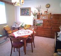 Innenraum in einem Einfamilienhaus, Esszimmer mit Retro-Möbeln, Fenster, Blumen, Tischdecke, Sessel.