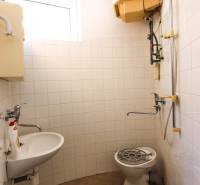 Badezimmer in Geschäftsräumen mit Dusche, Waschbecken und Fenster.