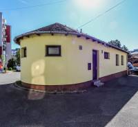 Gelbes rundes Gebäude zwischen Wohnhäusern in der Straße des Slowakischen Nationalaufstandes in Vrbové.