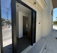 Der Eingang zum Ferienapartment in Ksamil hat Glastüren und ein helles Interieur.