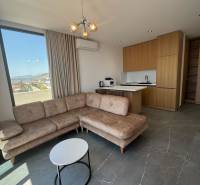 Wohnzimmer einer Ferienwohnung mit Ecksofa, Aussicht und Küchenzeile.