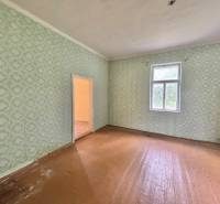 Geräumiges Zimmer in einem Einfamilienhaus mit Tapeten und Holzboden.