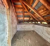 Dachboden eines Einfamilienhauses mit einem Holzdachstuhl und einem alten Holzbodenbelag.