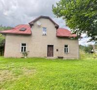 Einfamilienhaus im Zentrum, Makov, umgeben von einem grasbewachsenen Grundstück mit Bäumen.