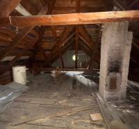 Das Dachgeschoss eines Einfamilienhauses mit Holzkonstruktion und einem gemauerten Schornstein.