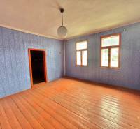 Ein Zimmer in einem Einfamilienhaus mit Holzboden und blauer Tapete.
