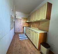 Schmale Küchenzeile mit Schränken und Bodenbelag in einer 3-Zimmer-Wohnung.