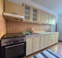 Küche mit Holzküchenzeile und Geräten in einer 3-Zimmer-Wohnung.