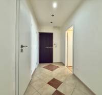 Der Flur mit Eingangstür und Fliesen in einer 4-Zimmer-Wohnung.