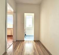Flur einer 4-Zimmer-Wohnung mit Holzböden und weißen Wänden.