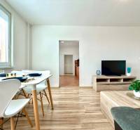 Wohnzimmer in einer 4-Zimmer-Wohnung mit Esstisch, Fernseher und Holzboden.