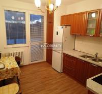 Küche und Raum in einer 2-Zimmer-Wohnung mit Holzküchenzeile und Tisch.
