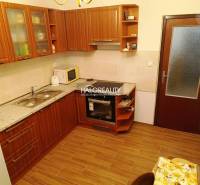 Eine Küche mit Holzschränken und Geräten in einer 2-Zimmer-Wohnung, optimal zum Kochen.
