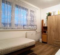 Das Zimmer bietet ein einfaches Bett und einen Holzschrank in einer 2-Zimmer-Wohnung.