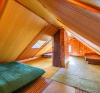 Dachboden in einer Hütte mit Holzwänden und ausziehbaren Sofas.