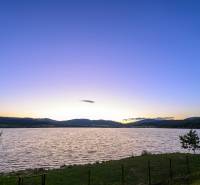 Ein See bei Sonnenuntergang, die ruhige Natur in der Umgebung von Ružiná und die Hütten.