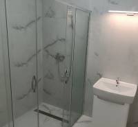 Badezimmer mit verglaster Duschkabine in einer 2-Zimmer-Wohnung.