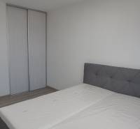 Schlafzimmer mit Doppelbett und Kleiderschrank in einer 2-Zimmer-Wohnung.