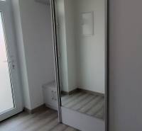 Der Flur einer 2-Zimmer-Wohnung mit weißen Türen und einem Einbauschrank.