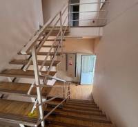 Eine Treppe im Gebäude mit Holzboden und Metallgeländer.