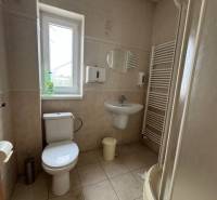 Badezimmer in Geschäftsräumen mit Sanitäranlagen, Dusche und Fenster für Tageslicht.