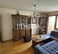 Wohnzimmer in einer 3-Zimmer-Wohnung mit Sofa, Schränken und Bücherregal am Fenster.