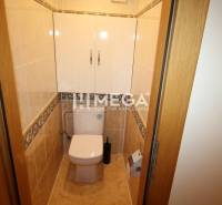 Toilette in einer 3-Zimmer-Wohnung mit hellen Fliesen und Stauraum über dem WC.