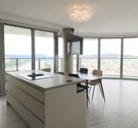 Küche mit Insel, Esstisch und Panoramablick in einer 3-Zimmer-Wohnung.
