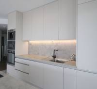 Küche in einer 3-Zimmer-Wohnung mit weißen Schränken und eingebauten Geräten.