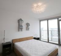 Schlafzimmer mit Bett und Kunst, großes Fenster mit Aussicht, 3-Zimmer-Wohnung.