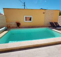 Ein Einfamilienhaus in Komárno mit einem Pool und Liegestühlen auf der Terrasse.
