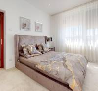 Helles Schlafzimmer mit großem Bett und dekorativen Kissen in einem Einfamilienhaus.